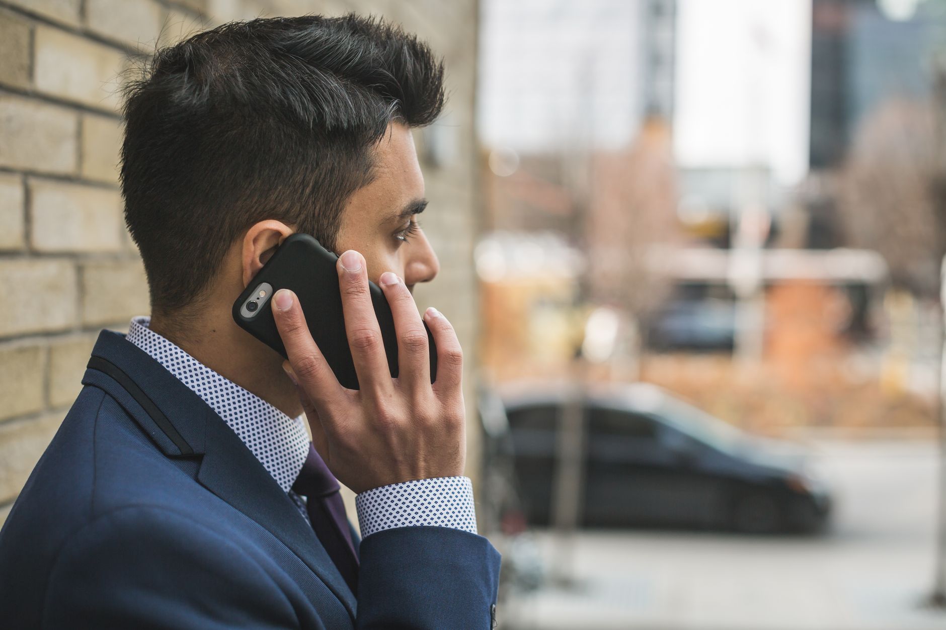 Professional man in suit making a phone call outside in city setting. — Boost Your Trading Performance with the Best Forex EA