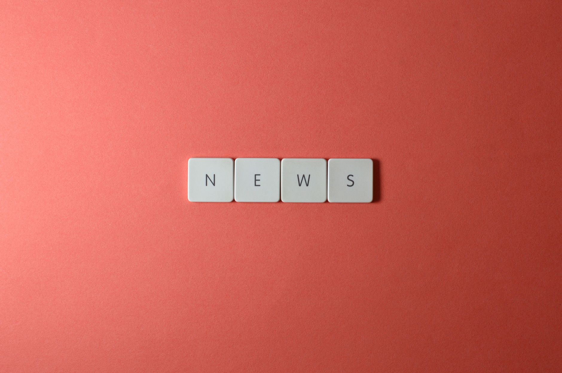 Close-up of keyboard keys spelling 'NEWS' on a red background, minimalist style. — How Astrology Guides Life Changes and Majo